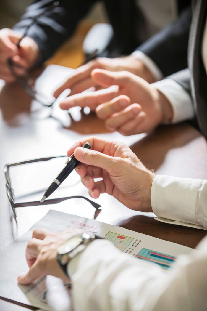 Closeup of hands with financial charts at business meeting in the office
