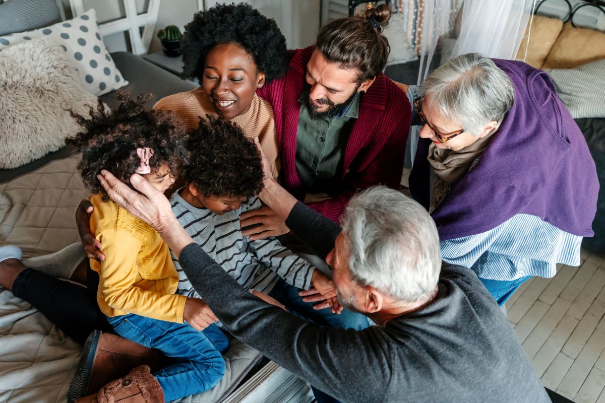 Multigenerational family hugging and smiling looking at each other 